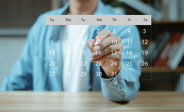 istock Businessman manages time for effective work. Calendar on the virtual screen interface. Highlight appointment reminders and meeting agenda on the calendar. Time management concept. 2246990654