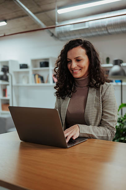istock Woman freelancer working on laptop in modern office smiling 2246992057