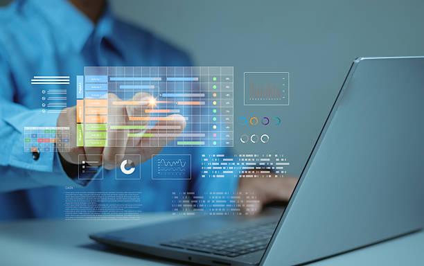 istock Businessman points to virtual project management dashboard showing Gantt charts, analytics and progress tracking. Data-driven planning, productivity and workflow concept. 2246993015