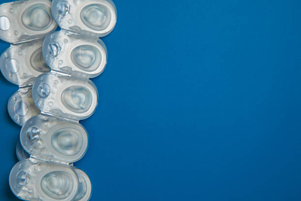 istock Many daily contact lenses in a disposable protective case in which clear lenses float lie on the side on a blue background with space for text. The concept of ophthalmology, vision correction, eye care. 2246993320