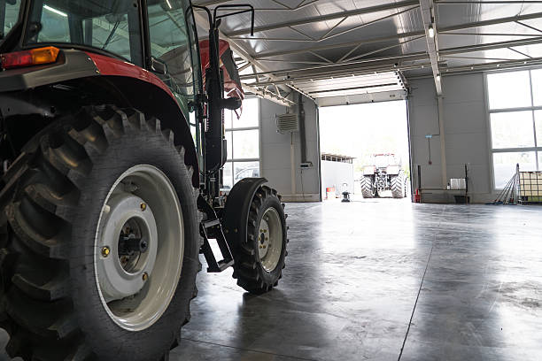 Agricultural tractor inside service garage, modern farm equipment storage and maintenance concept, industrial machinery and transportation.