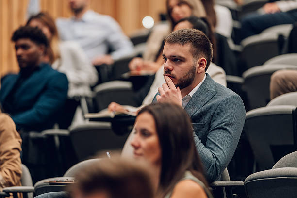 istock Young man listening thoughtfully at a business conference 2247002890