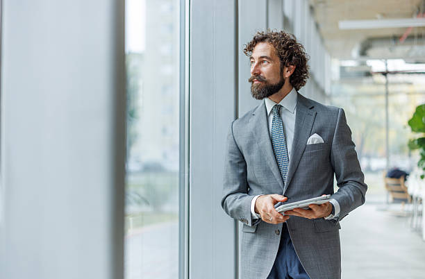 istock Businessman contemplating with tablet looking out office window 2247004812