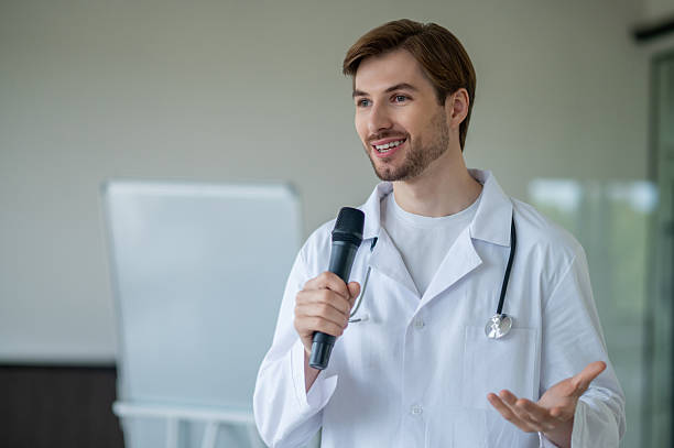 istock Male medical male presenting information at flipchart using microphone in clinic 2247011677