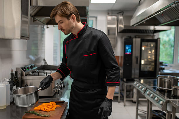 istock Skilled man working in restaurant standing near stove in culinary space 2247011998
