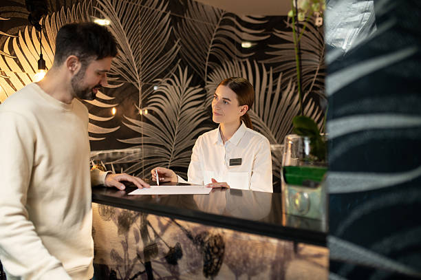 istock Receptionist talking to a male customer and arranging accommodation for him 2247012369
