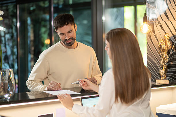 istock Receptionist talking to a male customer and arranging accommodation for him 2247012371