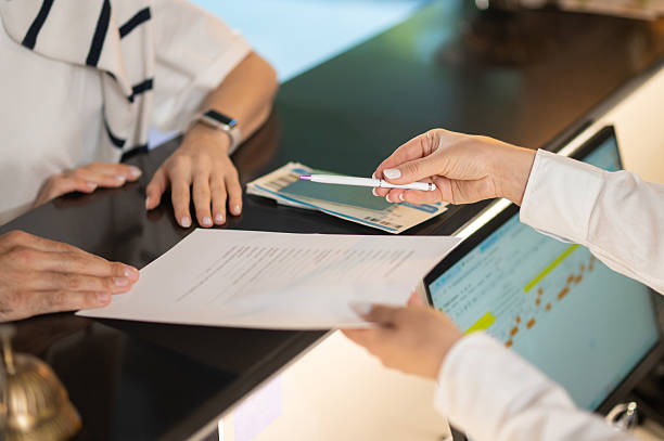 istock Close up picture of hands passing documents on a reception desk 2247012377