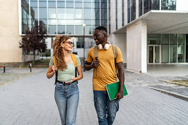 istock Diverse college students walking campus discussing education together 2247018526