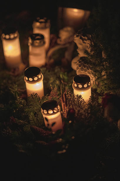 istock Memorial candles glowing warmly in darkness at night cemetery.. 2247020521