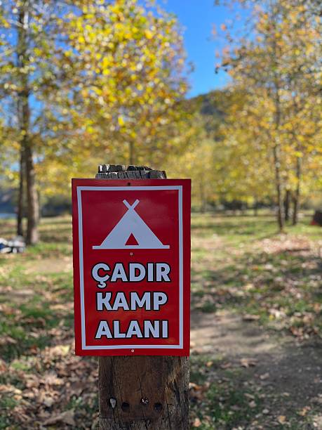 istock A metal sign erected in a forest area to indicate a tent or camping area. 2247027170