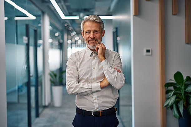 istock Mature businessman smiling with confidence in office hallway 2247027331