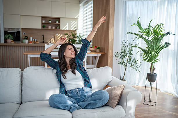 istock Young woman confidently stretching on comfortable sofa feeling happy at home 2247028371