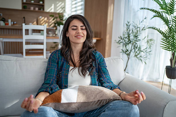 istock Woman meditating at home finding calm and wellness 2247028401
