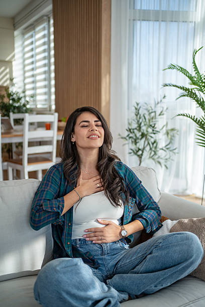 istock Woman practicing deep breathing exercise feeling peaceful at home 2247028455