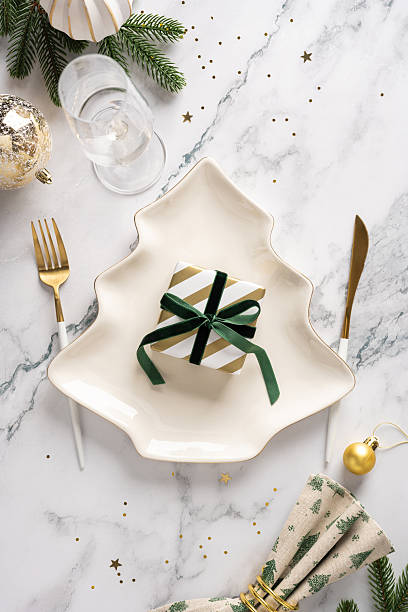 istock A vertical festive table scene featuring a star shaped plate, a wrapped gift, gold cutlery, and holiday decor, capturing Christmas and New Year celebration and warm greetings 2247028458