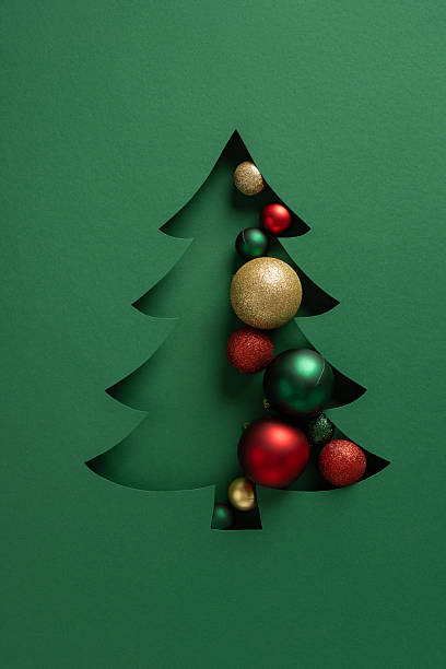 istock A green card features a stylized Christmas tree cutout filled with gold, red and green ornaments, creating a festive and modern look for Christmas and New Year greetings 2247028474