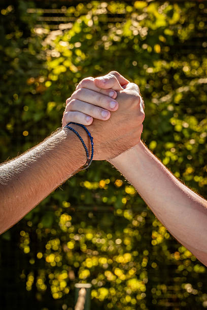 istock Two Hands Clasped in Solidarity, Symbolizing Teamwork and Support in Tennis 2247028800