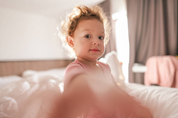Little Girl Playing in Bed, early morning