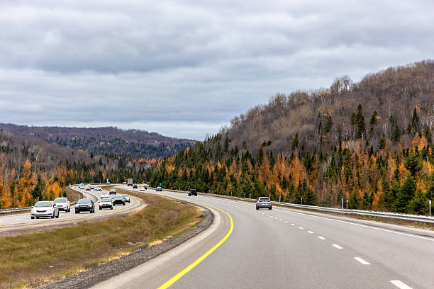 istock Highway traffic through autumn forest and hills under cloudy sky 2247034047