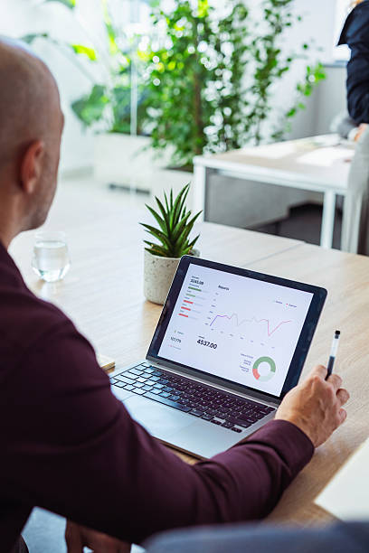 istock Professional Man Analyzing Data On Laptop In Bright Modern Office With Green Plant 2247035494