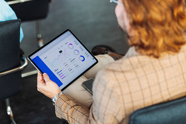 istock Business Professional Analyzing Data On Tablet During Meeting In Modern Office 2247035559