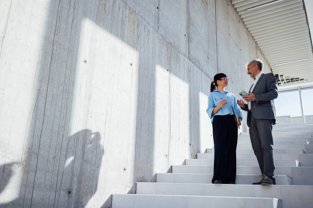 istock Business Professionals Discuss Plan On Modern Outdoor Staircase Beside Concrete Wall During Daylight Meeting 2247035562