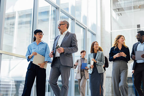 istock Diverse Office Team Walking and Chatting in Modern Glass Atrium, Professional Collaboration and Networking 2247035577