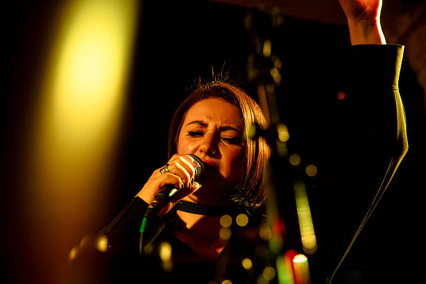 istock Female singer performing on stage with dramatic lighting in close-up 2247039393