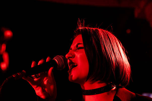 istock Female singer performing on stage under red lights 2247039403