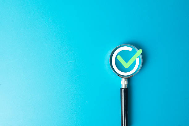istock Magnifying Glass focusing on Green Checkmark Icon 2247039968