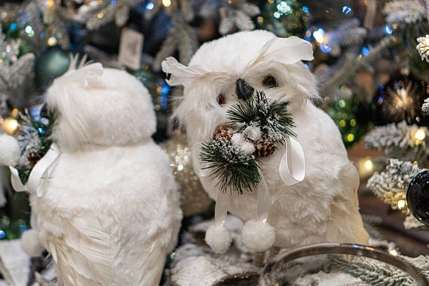 istock Two white owls sit on a decorated Christmas tree branch, with festive lights and pine cones Cozy holiday atmosphere, soft shadows, warm colors, and whimsical style 2247041809
