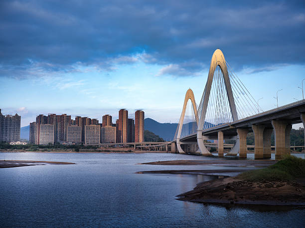 istock Modern Cable - Stayed Bridge and Urban Buildings by the River 2247042000