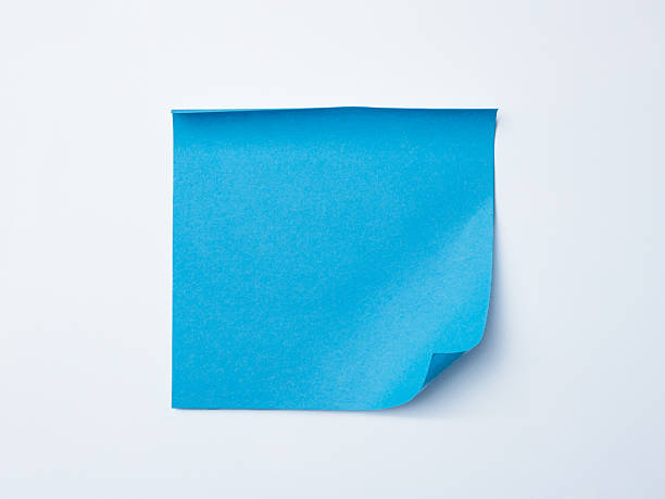 istock Single blue sticky note with curled corner placed on a clean white background. Ideal for office, reminder, stationery, or minimalist design themes. 2247044385