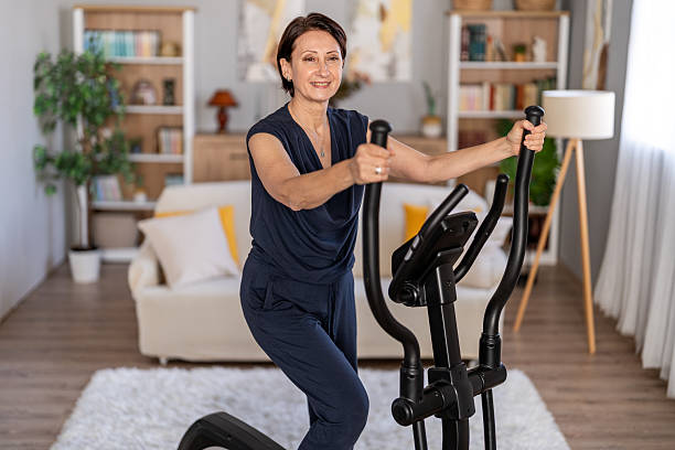 istock Senior woman training on elliptical machine at home 2247045677