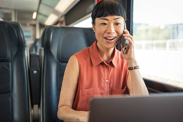 istock Businesswoman working on laptop and talking on phone while riding train 2247045699