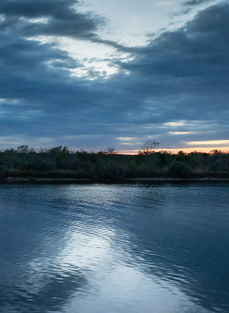 istock ertical Dark Water and Dramatic Cloudy Sky at Dusk or Dawn with Orange Horizon Line 2247046670