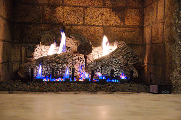 Cozy Fireplace With Logs And Blue Flames In Stone Setting For Home Ambiance