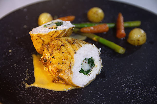 Delicious chicken roulade stuffed with sauce and vegetables on a plate