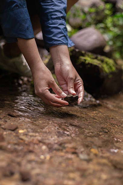 istock Hands of a Woman Reaching Into a Flowing River 2247051697