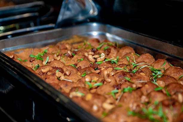 Close-up of Kung Pao chicken garnished with dried chilies and green peppers, served on a white plate at a Chinese restaurant.