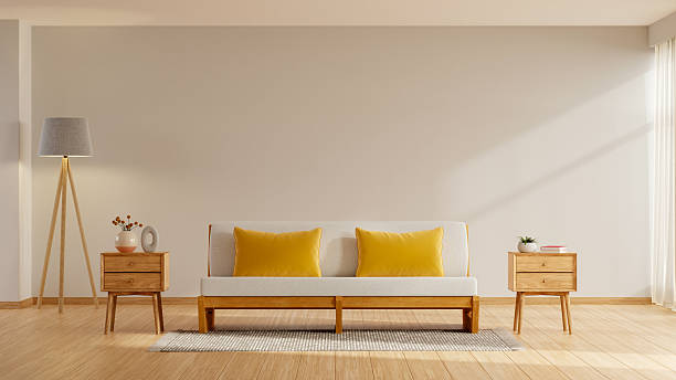 istock Cozy and minimalist living room interior design featuring a simple, light wooden sofa with bright yellow cushions centered against a large blank beige wall- 3D rendering 2247062448