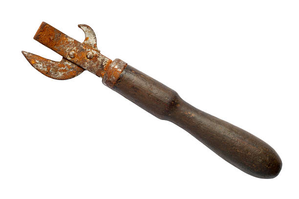 An old canned food opener with a wooden handle. Rusty Opener