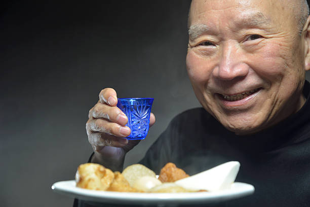 istock A senior smiling as he eats steaming oden 2247064994