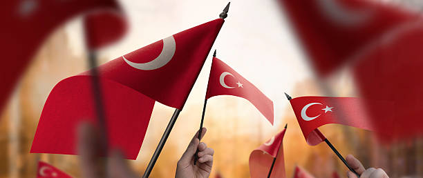 istock Turkey flags in their hands on a blurred urban background 2247066935