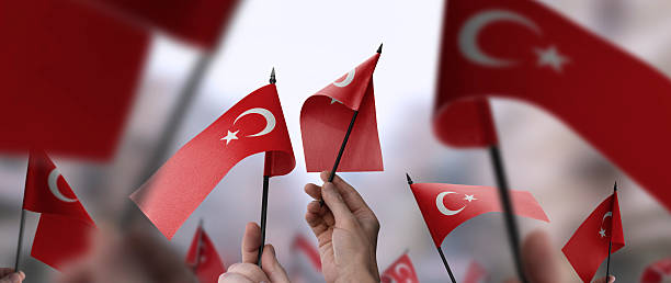 istock Turkey flags in their hands on a blurred urban background 2247066939