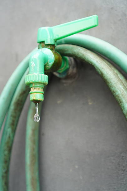 istock Drip falling from a closed green plastic faucet 2247072090