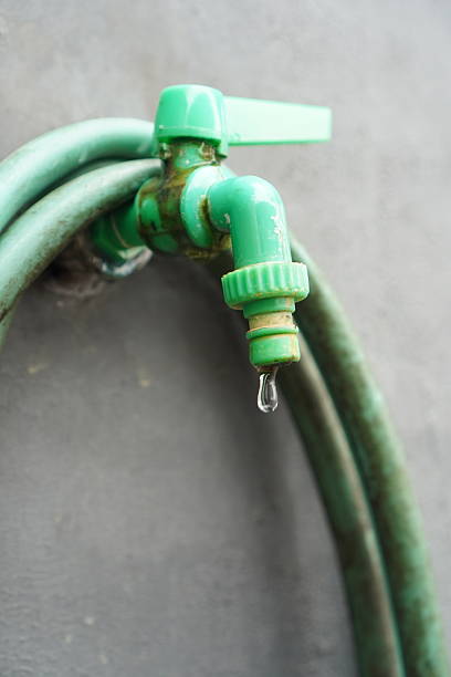 istock Drip falling from a closed green plastic faucet 2247072115