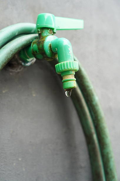 istock Drip falling from a closed green plastic faucet 2247072116