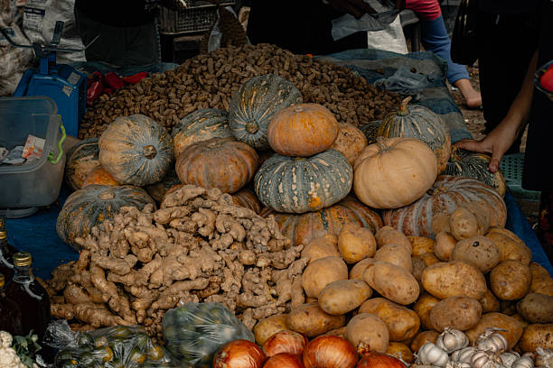 Various organic vegetables like pumpkins and ginger displayed in a local weekend market